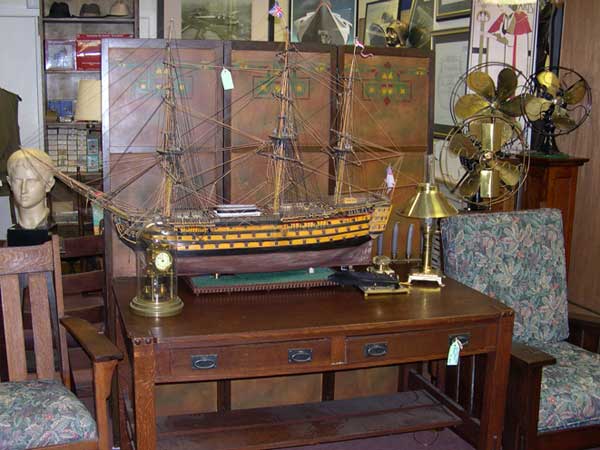 Antique furniture with ship statue and old brass fans
