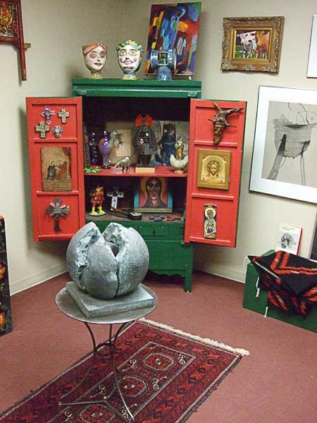Eclectic mix of nick knacks in a green and red cabinet.