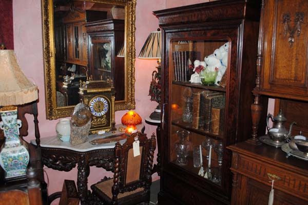 Antique wood furniture including tall dresser, small sideboard table and grandfather clock.